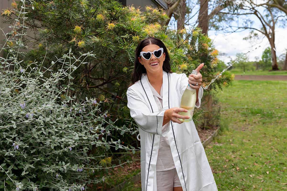 bride popping champagne at cabins at glenworth valley